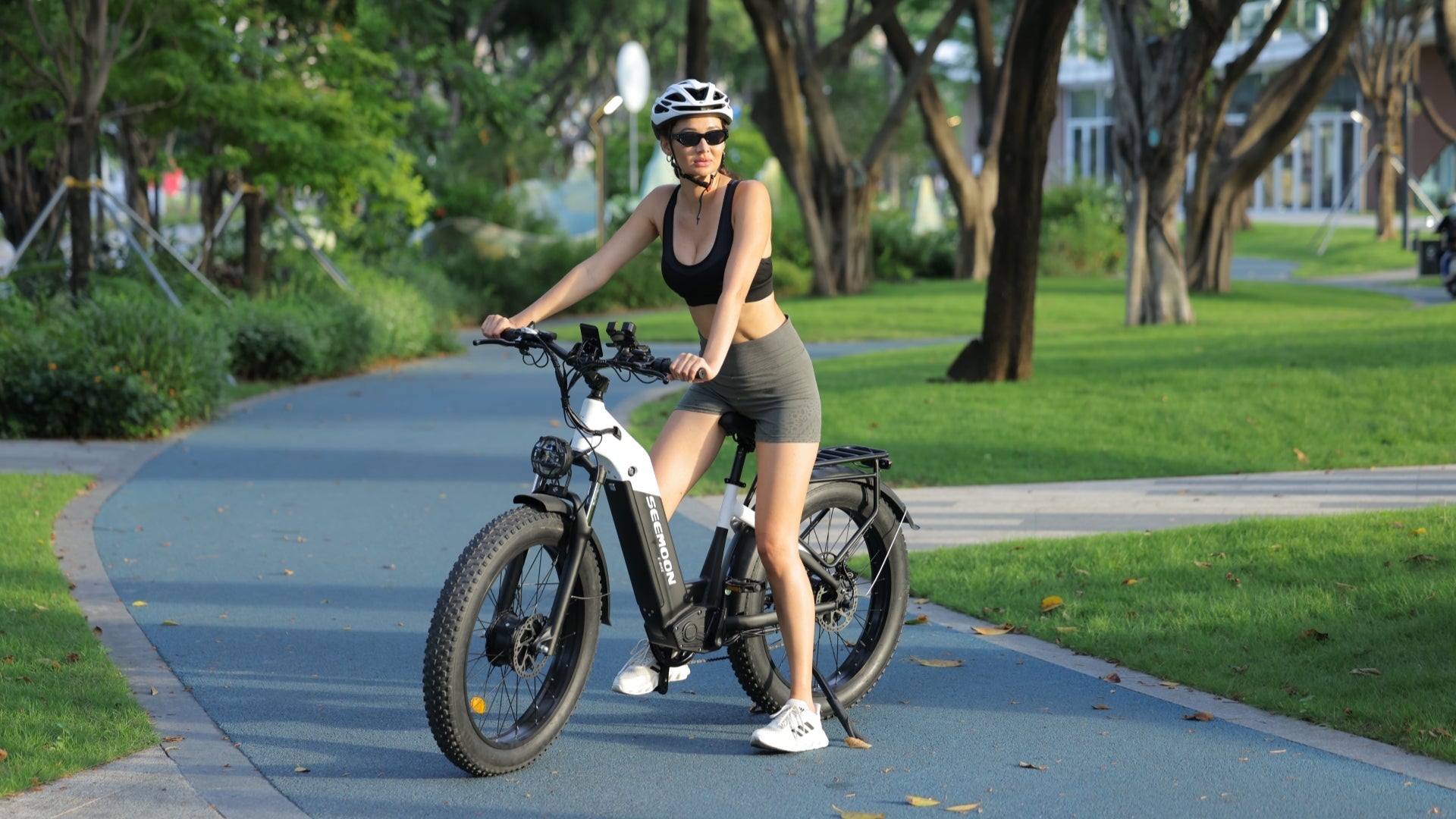 The girl is riding a white SM series electric bicycle, highlighting its superior quality.