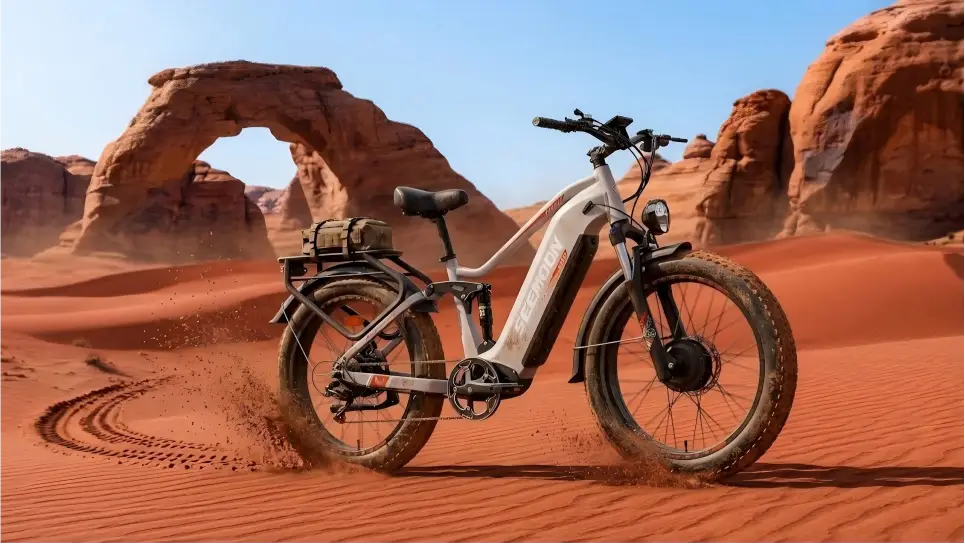 Seemoon SM3 all-terrain AWD electric bike riding across soft red sand dunes in the desert.